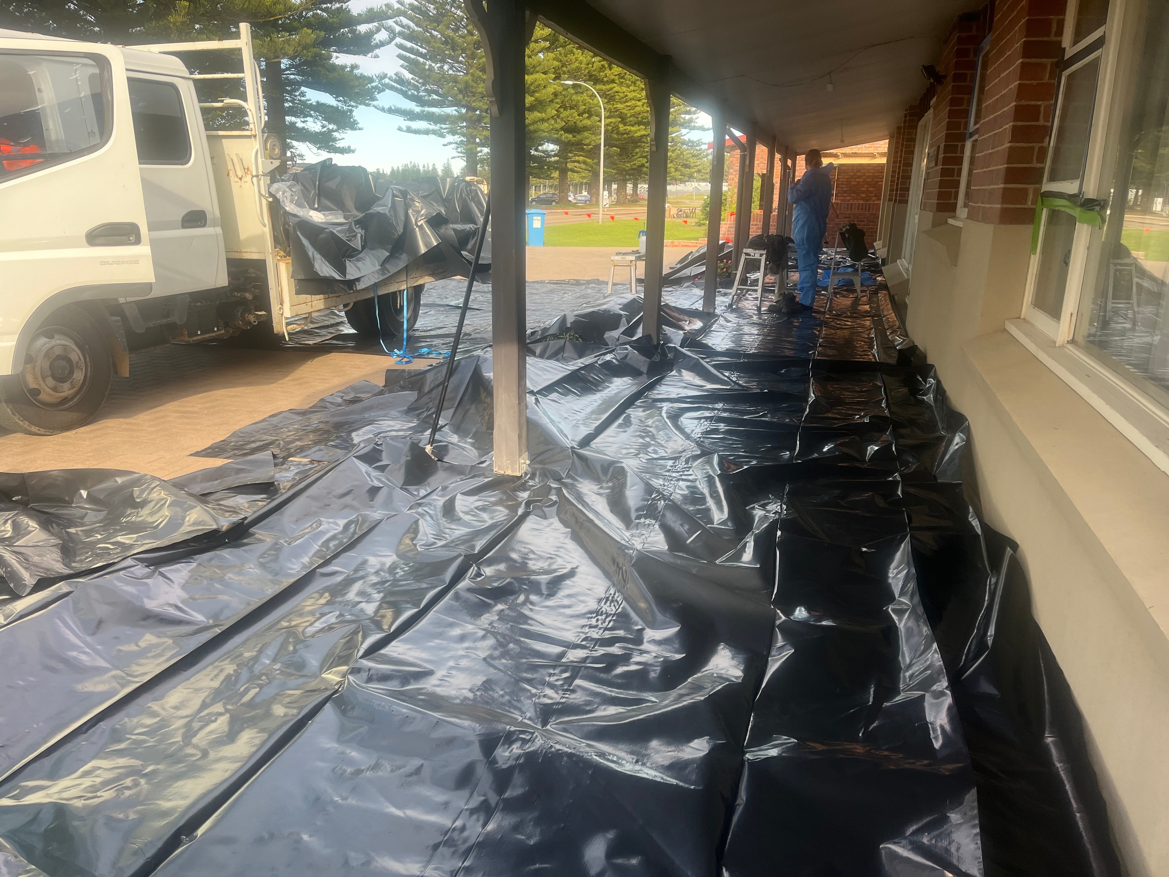 Asbestos removal team in full PPE protective coveralls and breathing masks