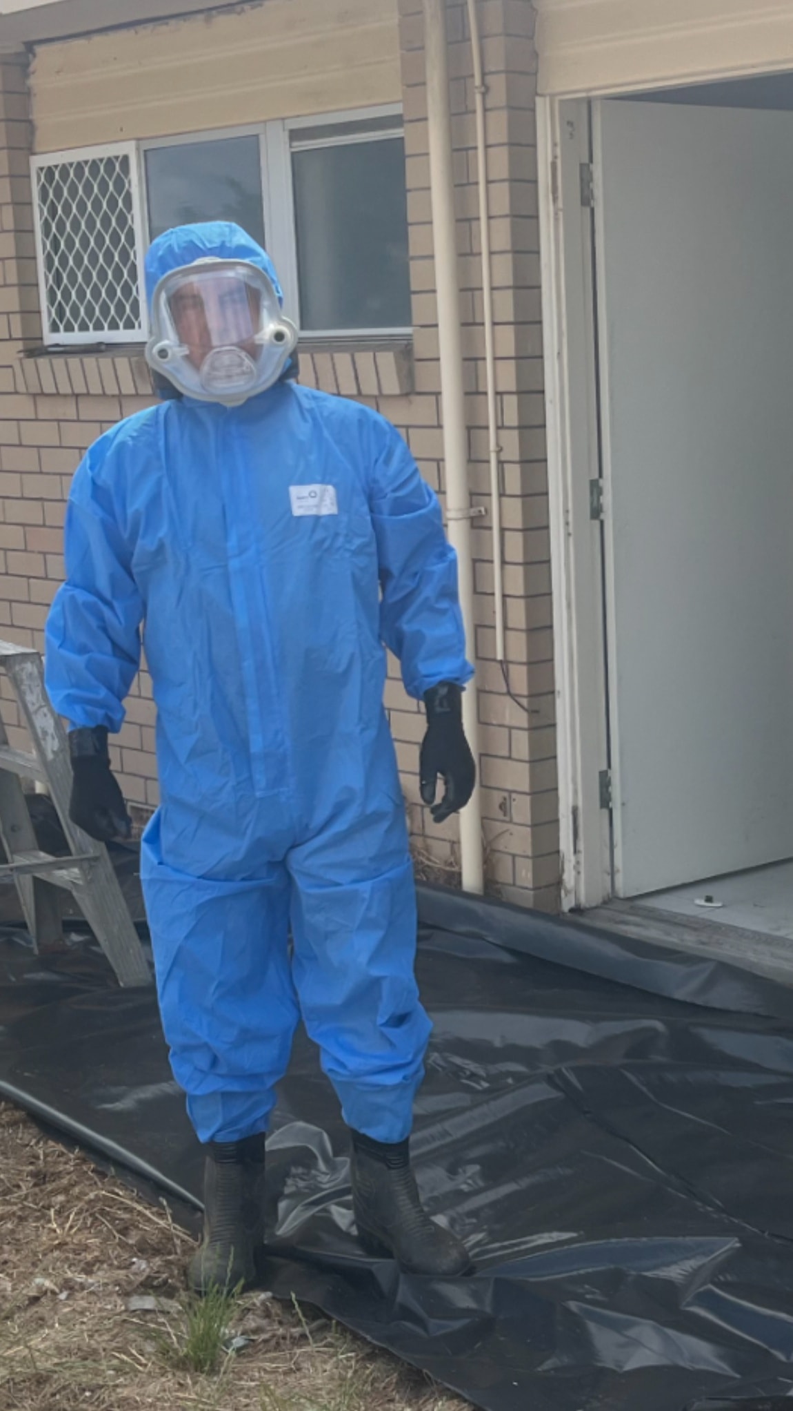 CleanSlate worker in full PPE blue suit on site